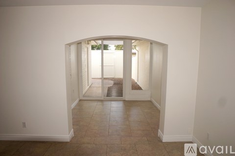 A room with a tiled floor and a doorway leading to a balcony.