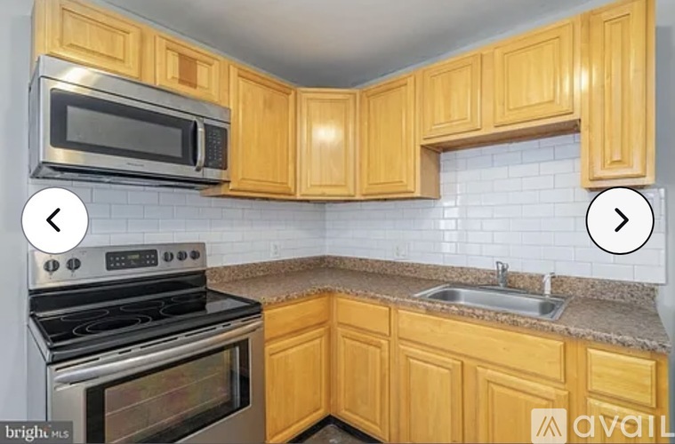 A kitchen with wooden cabinets and a stainless steel oven.