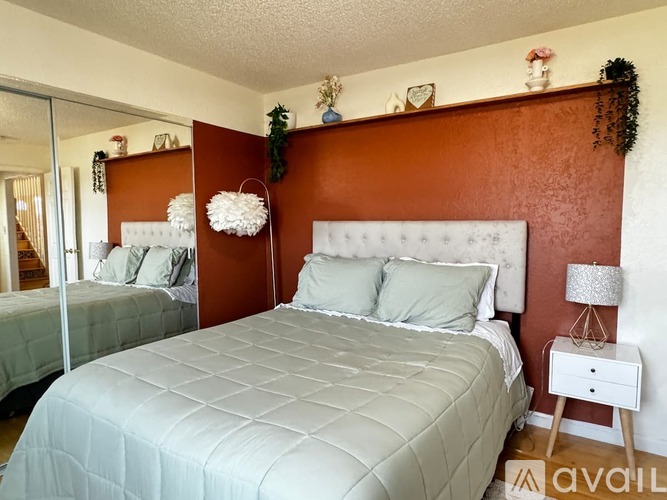 A bedroom with a white bed and a brown headboard.
