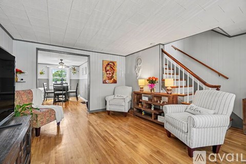 A living room with a striped couch and a wooden floor.