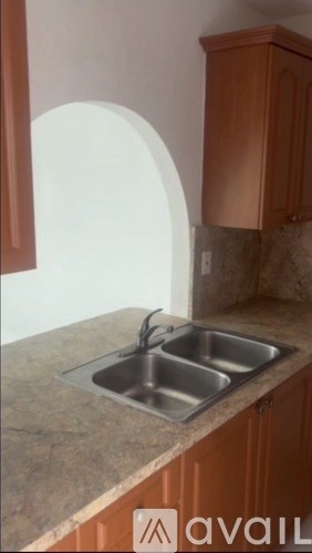 A kitchen with a sink and brown cabinets.