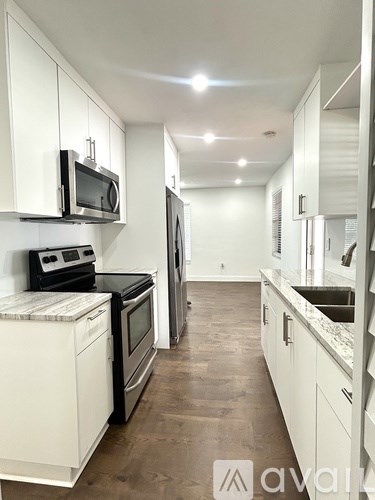 A kitchen with white cabinets and appliances.