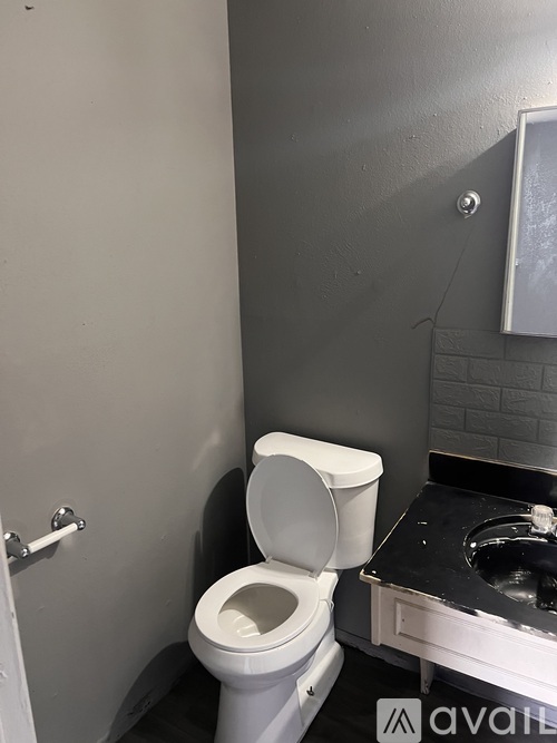 A white toilet in a bathroom with a black counter.