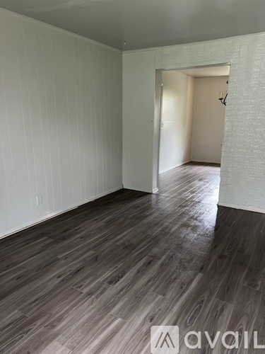 A room with wooden flooring and white walls.