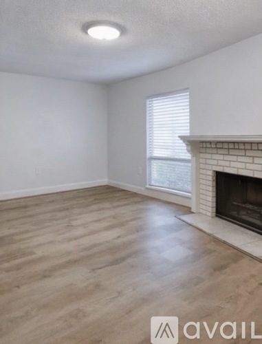 A room with a fireplace and a window with blinds.