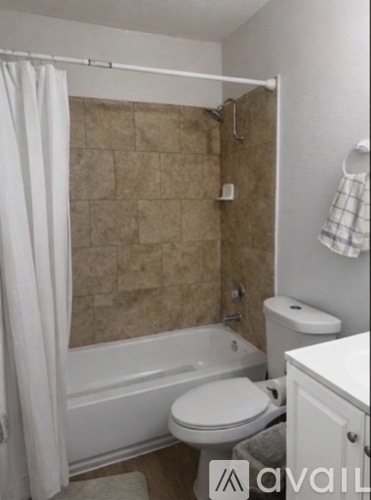 A bathroom with a toilet, tub, and sink.