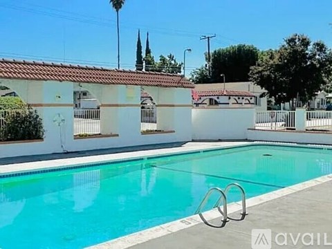 A pool with a diving board in front of a house.