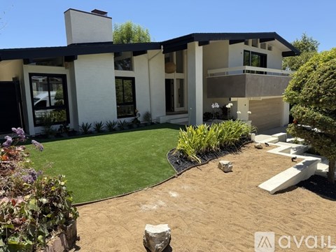 A modern house with a white exterior and a black roof.