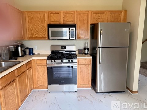 A kitchen with wooden cabinets and a stainless steel refrigerator.