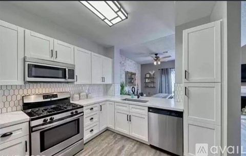 A kitchen with white cabinets and stainless steel appliances.
