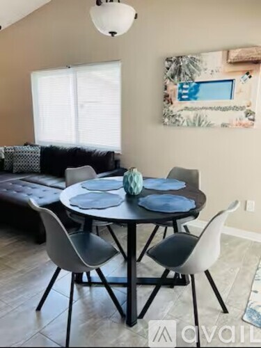 A dining table with four chairs around it.