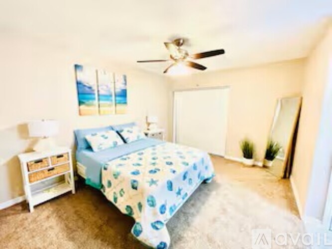A bedroom with a bed, nightstand, and a ceiling fan.