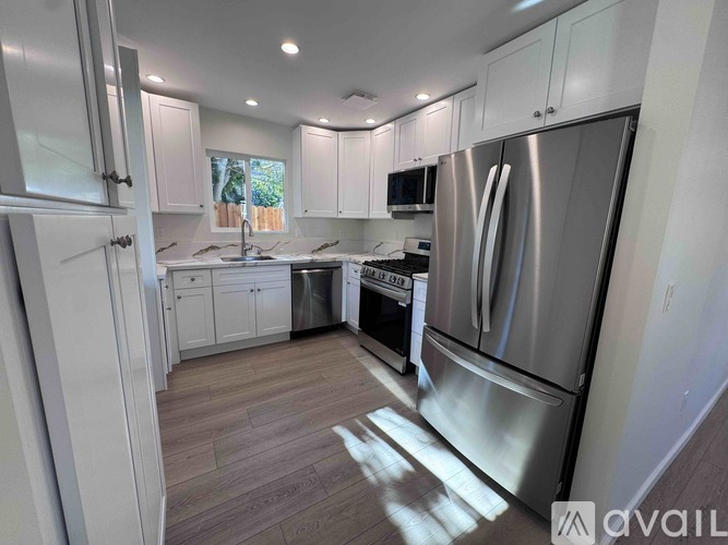 A modern kitchen with stainless steel appliances and white cabinets.