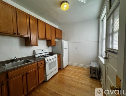 A kitchen with wooden cabinets and a white stove top oven.