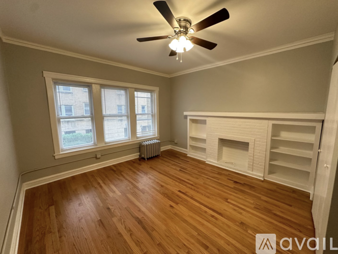 A room with wooden floors and a ceiling fan.