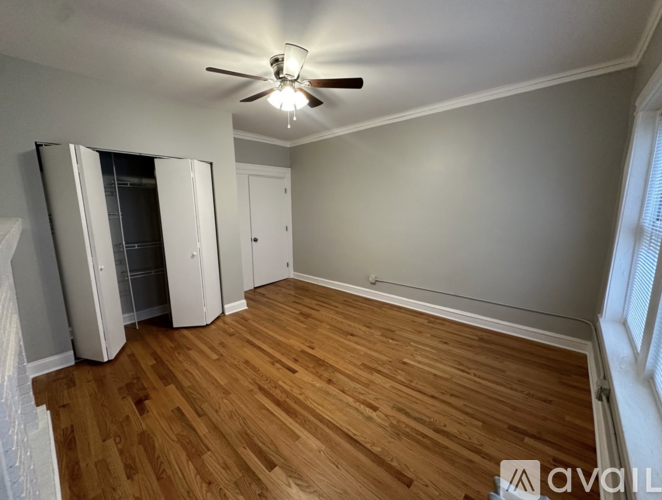 A room with wooden flooring and a ceiling fan.
