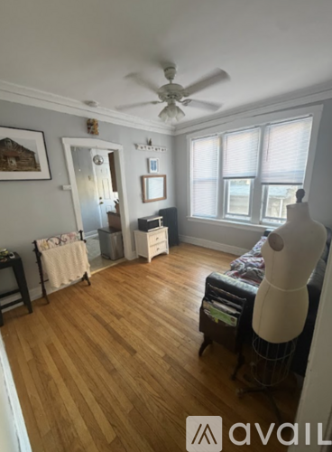 A room with wooden floors and a ceiling fan.