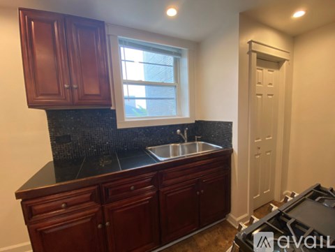 A kitchen with wooden cabinets and a black countertop.