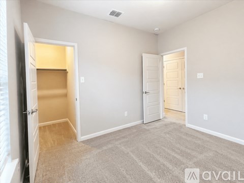 A spacious room with a carpeted floor and two doors.