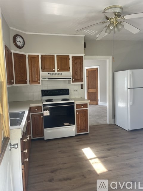 A kitchen with wooden cabinets and a white refrigerator.