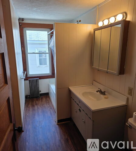 A bathroom with a sink, mirror, and a window.