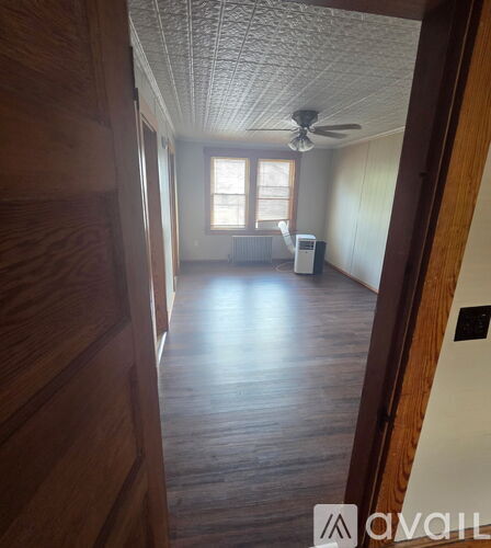 A room with wooden floors and a ceiling fan.