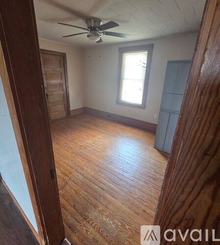 A room with wooden floors and a ceiling fan.