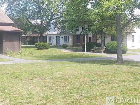 A house with a lawn and trees in front of it.