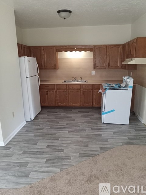 A kitchen with wooden cabinets and a white refrigerator.