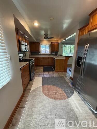 A kitchen with a refrigerator on the right side.