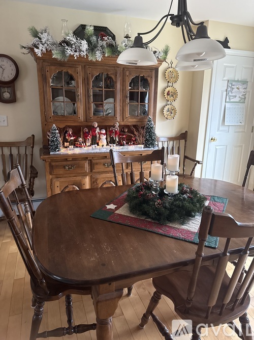 A dining room decorated for Christmas with a wreath on the table.