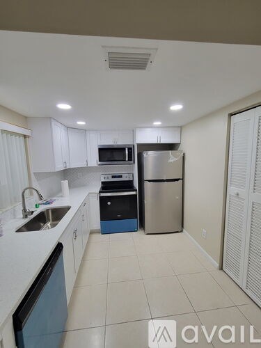 A kitchen with white cabinets and a blue dishwasher.