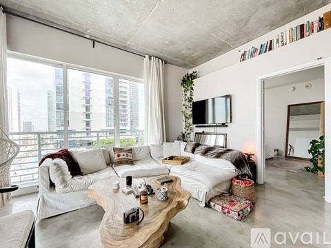 A living room with a white couch and a wooden coffee table.