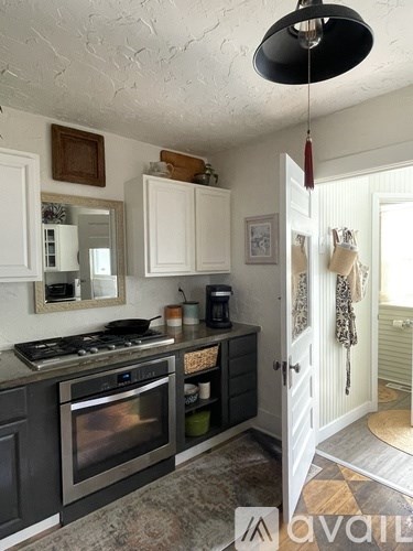 A kitchen with a black stove top oven and white cabinets.