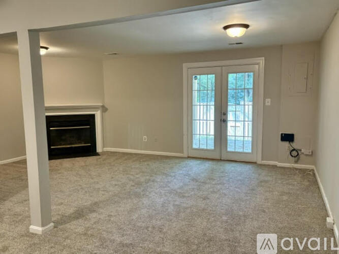 A living room with a fireplace and a carpeted floor.