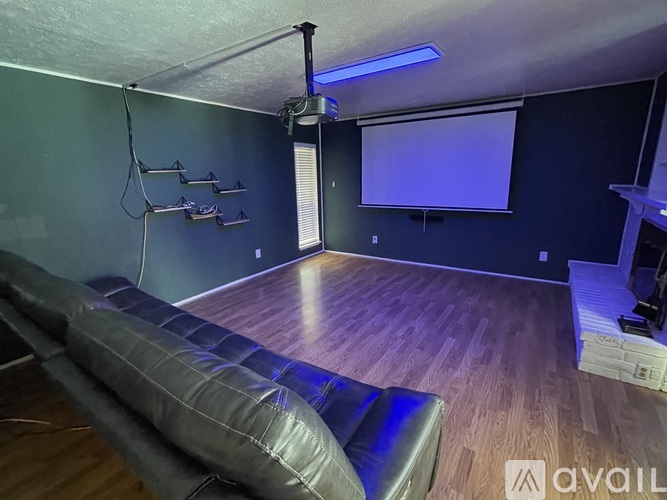 A room with a couch, a projector, and a screen.