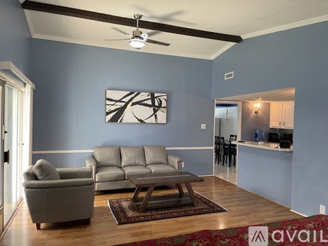 A living room with a grey couch and a brown coffee table.