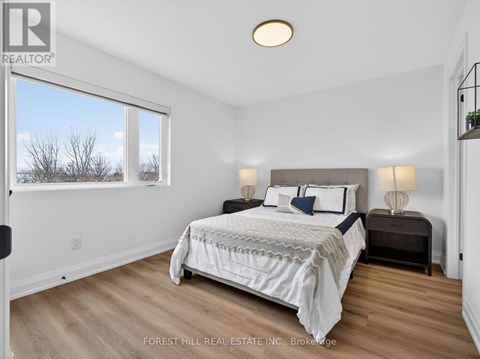 A bedroom with a large bed and a window overlooking a snowy landscape.