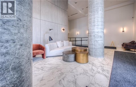 A living room with a white couch and a marble floor.