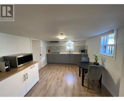A kitchen with a microwave, oven, and sink.