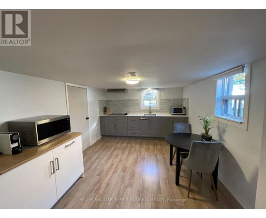 A kitchen with a microwave, oven, and sink.