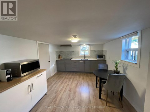 A kitchen with a microwave, oven, and sink.