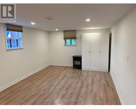 A room with wooden flooring and a white wall.