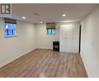 A room with wooden flooring and a white wall.