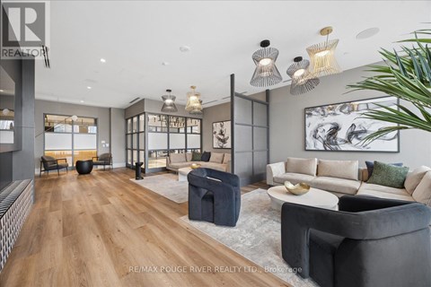 A modern living room with a grey sofa and a wooden floor.