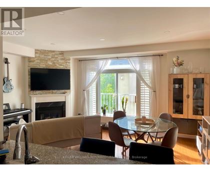 A living room with a fireplace and a dining table.