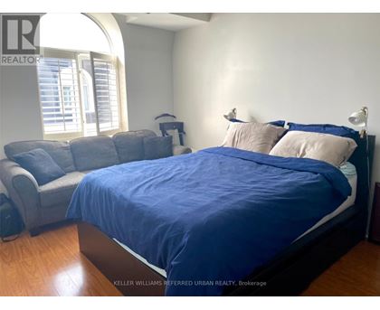 A bedroom with a bed and a couch.