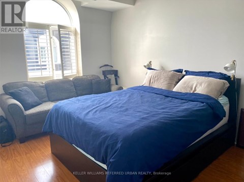 A bedroom with a bed and a couch.