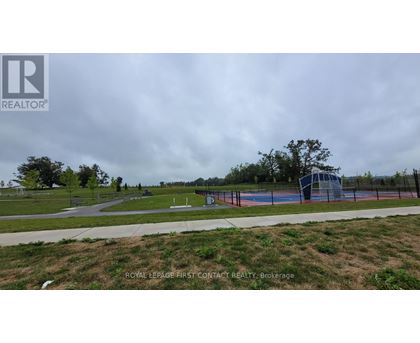 A park with a basketball court and a fence surrounding it.