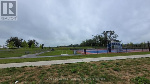 A park with a basketball court and a fence surrounding it.